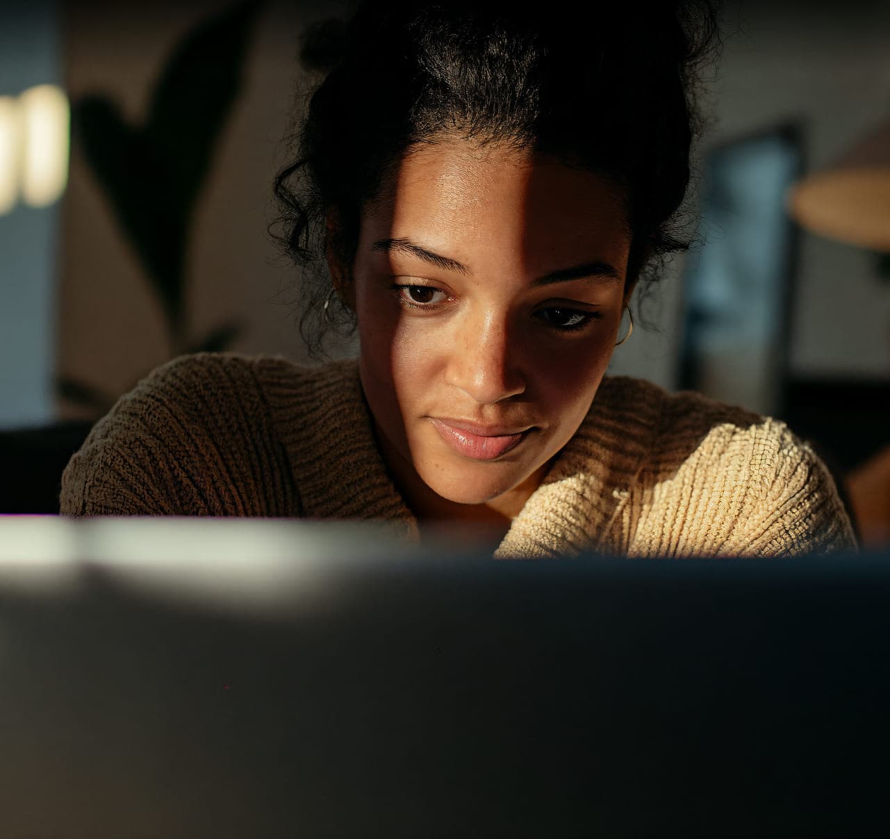 A behavioral-health facility manager focused on her laptop in the evening.